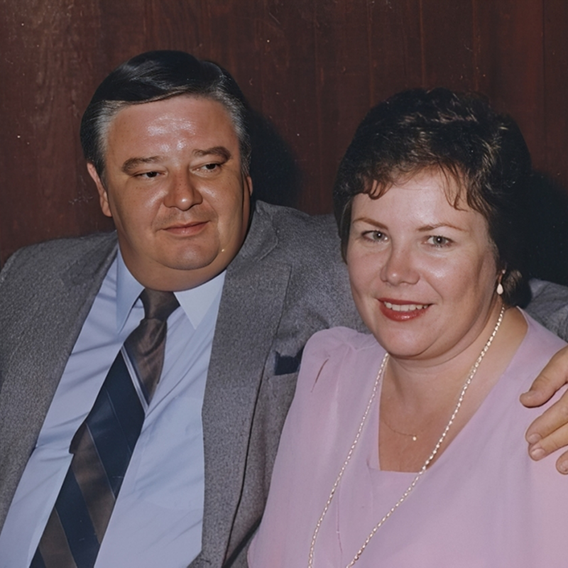 Smiling couple posing together, formal attire.