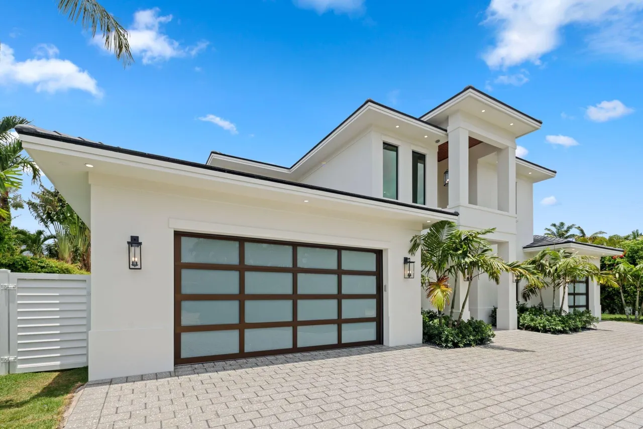 Modern white house with glass garage doors.